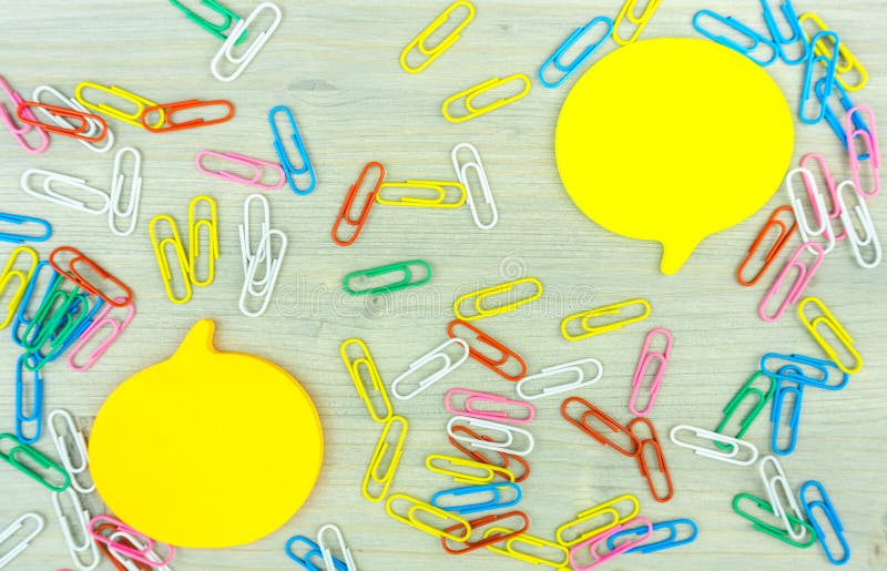 Note jaune de bulle de la parole avec l'ensemble de trombones colorés sur le fond en bois concepts de cr?ativit? d'affaires photos libres de droits Note jaune de bulle de la parole avec l'ensemble de trombones colorés sur le fond en bois concepts de cr?ativit? d'affaires photos libres de droits