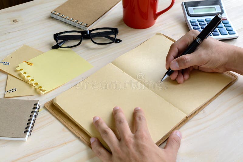 Notebook with Cup of Coffee and Office Supply on Desk Stock Photo