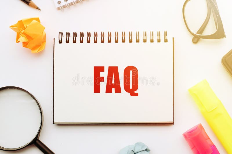 A notebook displaying the word FAQ sits next to a magnifying glass, symbolizing the act of finding answers to frequently asked royalty free stock photography