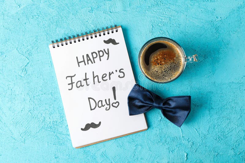 Notebook with inscription happy fathers day, blue bow tie and cup of coffee on color background, space for text and top view