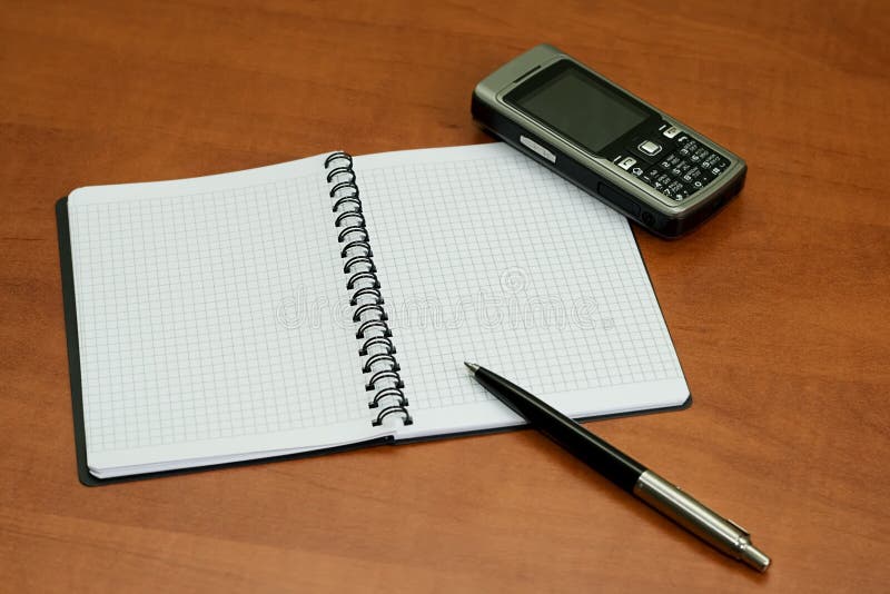 Notebook pen and mobile phone on table