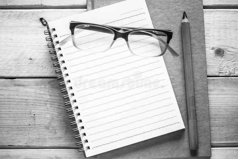 Notebook , pencil and eyeglasses on wood table