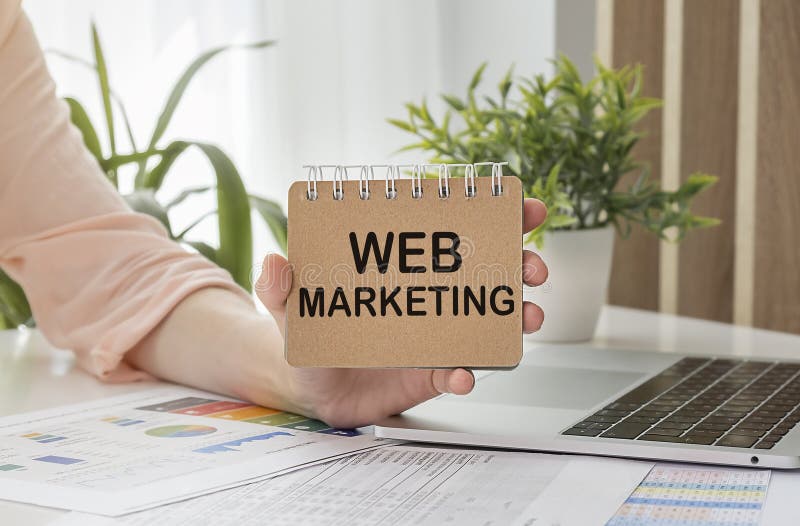 Notebook with Toolls and Notes about Web Marketing in hand, business concept stock image
