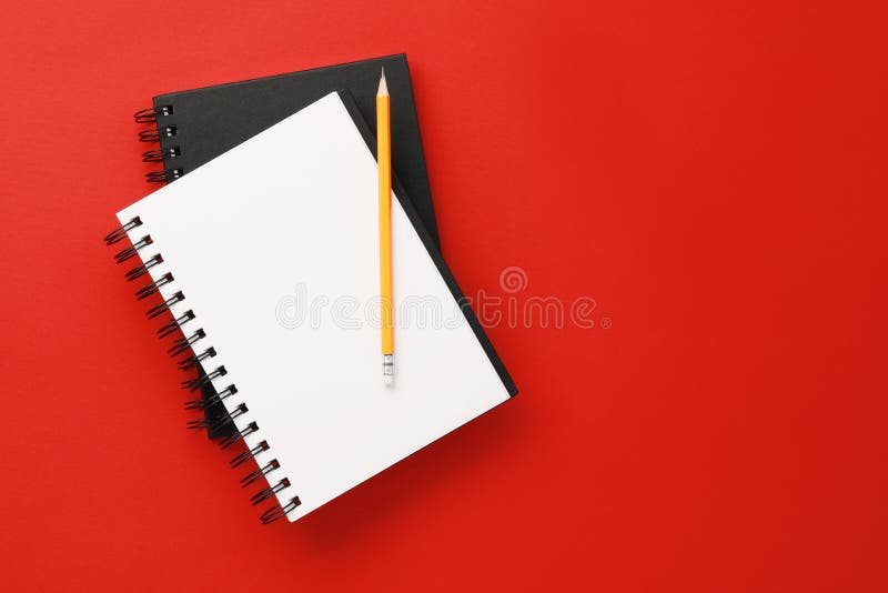 Notebooks and pencil on red background, top view. Space for text stock photography