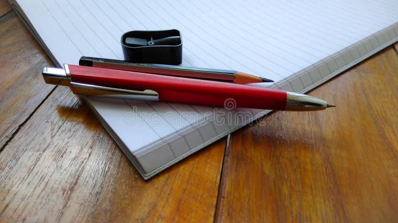 Notebooks, pens and pencils on wooden