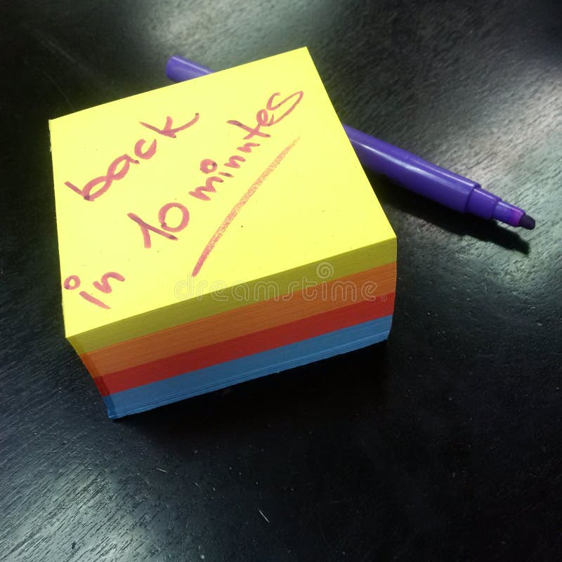 Notepad of color papers with message, back in 10 minutes royalty free stock photo