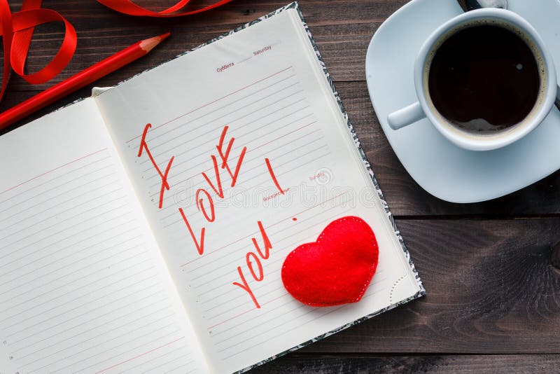 Notepad and pencil with love on table.