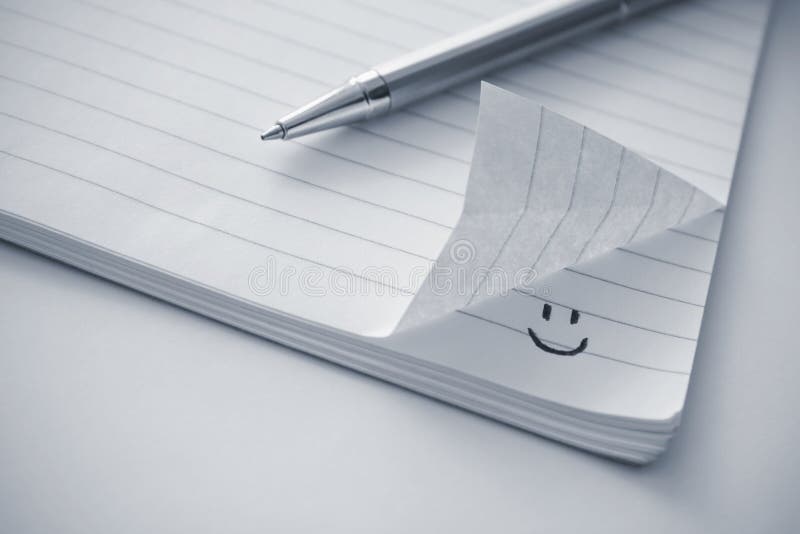 Notepad with a smiley icon stock photography
