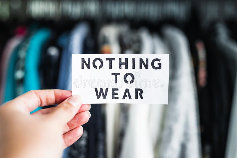 Shopping and consumerism, Nothing to Wear sign ironically held in front of wardrobe full of clothes royalty free stock photos Shopping and consumerism, Nothing to Wear sign ironically held in front of wardrobe full of clothes royalty free stock photos