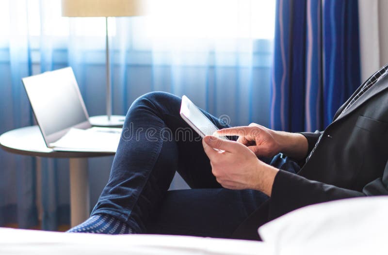 Noticias o correo electrónico de la lectura del hombre de negocios con la tableta en la habitación imágenes de archivo libres de regalías Noticias o correo electrónico de la lectura del hombre de negocios con la tableta en la habitación imágenes de archivo libres de regalías