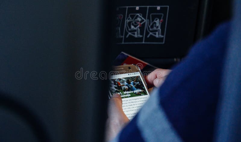 Notícia da leitura da mulher no smartphone no avião usando Wi-Fi fotos de stock Notícia da leitura da mulher no smartphone no avião usando Wi-Fi fotos de stock