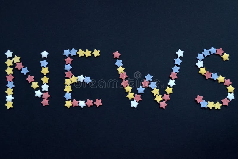 A notícia da palavra é escrita no tipo fino de estrelas da pastelaria do açúcar em um fundo preto, anunciando, comércio, vendas fotografia de stock A notícia da palavra é escrita no tipo fino de estrelas da pastelaria do açúcar em um fundo preto, anunciando, comércio, vendas fotografia de stock