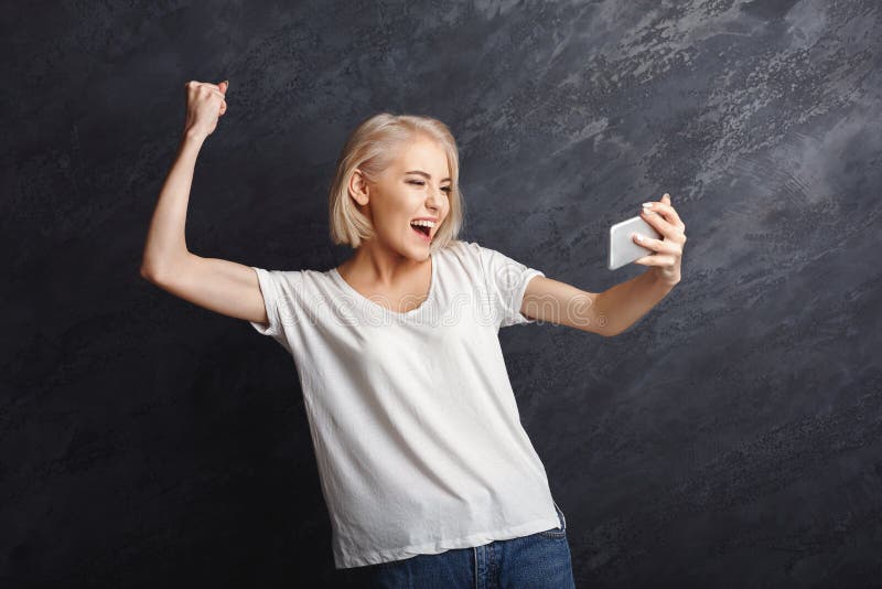 Notícia de leitura da menina feliz boa no móbil fotos de stock Notícia de leitura da menina feliz boa no móbil fotos de stock