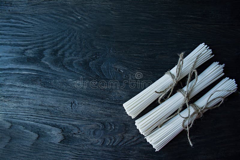 Nouilles crues d'udon en petits pains sur un fond en bois fonc? Place pour le texte Vue de ci-avant photos stock Nouilles crues d'udon en petits pains sur un fond en bois fonc? Place pour le texte Vue de ci-avant photos stock