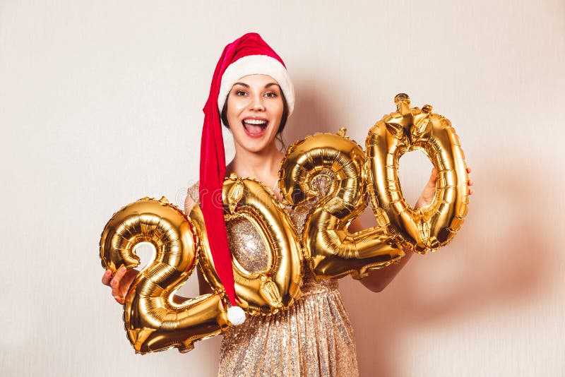 Nouvel An 2020 Nombre d'or Ballons Belle femme aux ballons célébrant la fête de la Saint-Sylvestre Au Nouvel An rouge photo libre de droits Nouvel An 2020 Nombre d'or Ballons Belle femme aux ballons célébrant la fête de la Saint-Sylvestre Au Nouvel An rouge photo libre de droits