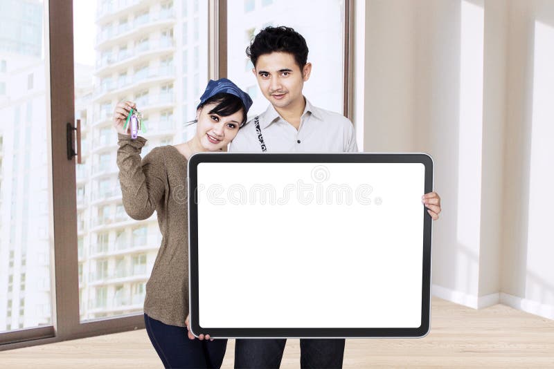 Nouvelle maison de propriétaires montrant une clé et un conseil vide image stock Nouvelle maison de propriétaires montrant une clé et un conseil vide image stock
