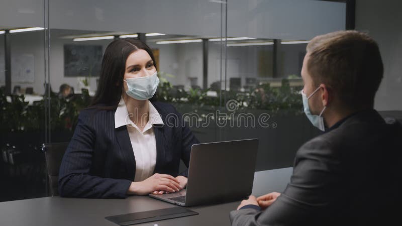 Nouvelles négociations normales et commerciales. jeune femme d'affaires en masque facial protecteur parler avec un partenaire masc banque de vidéos