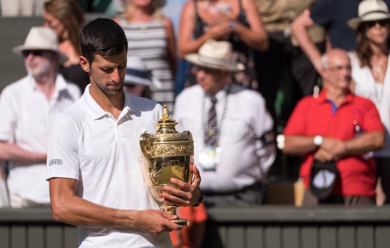 Novac Djokovic, serbisk spelare, segrar Wimbledon för den fjärde gången I fotoet rymmer han trofén på mittdomstolen royaltyfri bild Novac Djokovic, serbisk spelare, segrar Wimbledon för den fjärde gången I fotoet rymmer han trofén på mittdomstolen royaltyfri bild