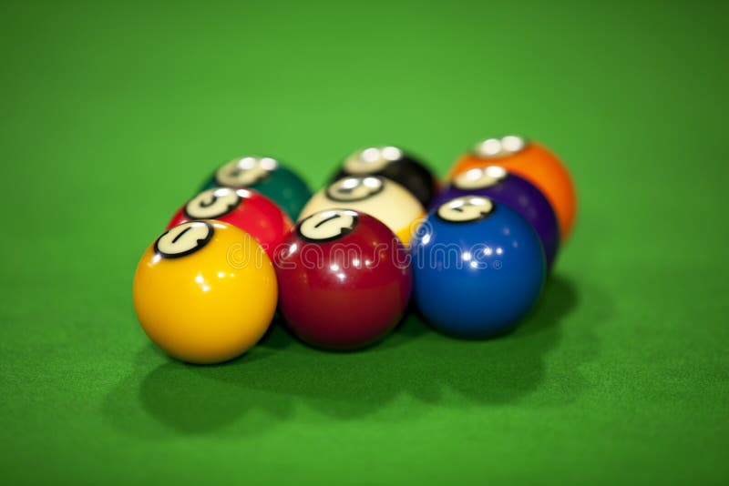 Nine billiard balls on a billiard table with the focus on the yellow ball number one. Nine billiard balls on a billiard table with the focus on the yellow ball number one