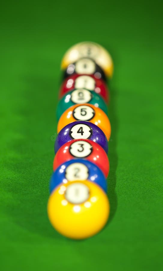 Nine billiard balls on a billiard table lying in a row with the focus on the purple ball number four. Nine billiard balls on a billiard table lying in a row with the focus on the purple ball number four
