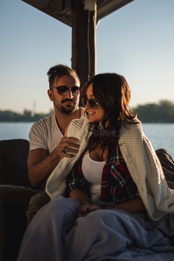 Novia de la cubierta del hombre con el suéter por el río fotos de archivo libres de regalías Novia de la cubierta del hombre con el suéter por el río fotos de archivo libres de regalías