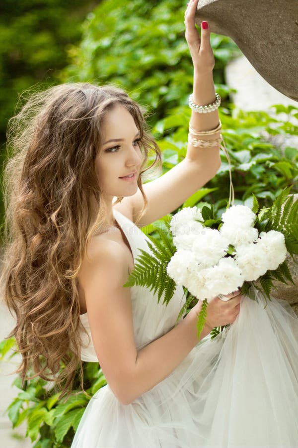 Novia feliz hermosa con maquillaje largo del pelo ondulado y de la boda ho foto de archivo libre de regalías Novia feliz hermosa con maquillaje largo del pelo ondulado y de la boda ho foto de archivo libre de regalías