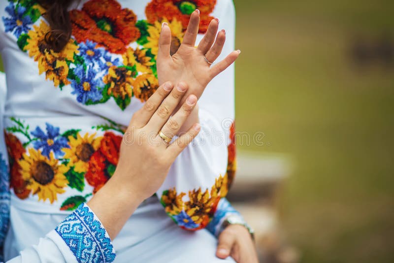 Novia feliz y novio ucranianos que muestran sus manos con los anillos después de la ceremonia, ropa bordada fotografía de archivo libre de regalías Novia feliz y novio ucranianos que muestran sus manos con los anillos después de la ceremonia, ropa bordada fotografía de archivo libre de regalías