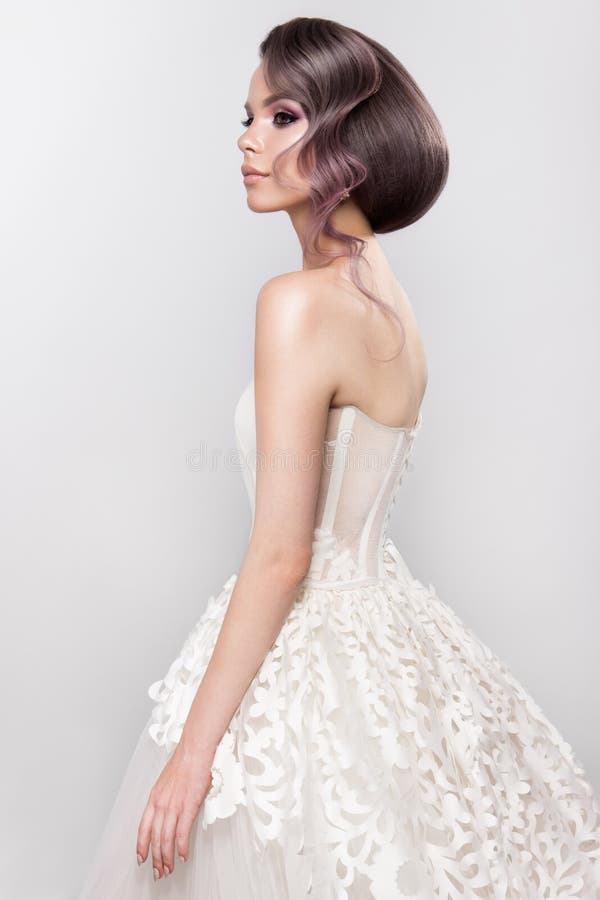Novia hermosa con el peinado de la boda de la moda - en el fondo blanco fotografía de archivo Novia hermosa con el peinado de la boda de la moda - en el fondo blanco fotografía de archivo