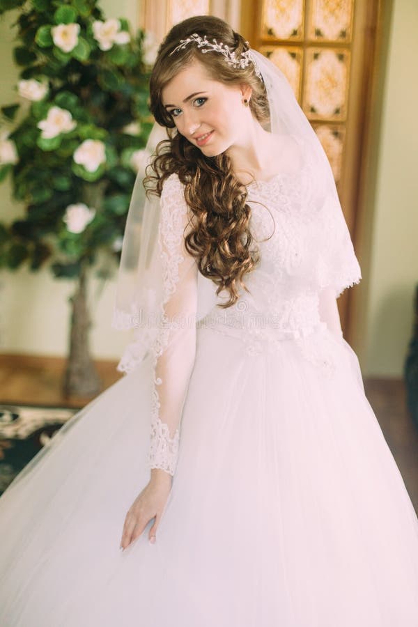 Novia Hermosa En Vestido De Boda Blanco Elegante Y Velo Con El Pelo Rizado  Largo Que Presenta Dentro Imagen de archivo - Imagen de gente, sitio:  70956643