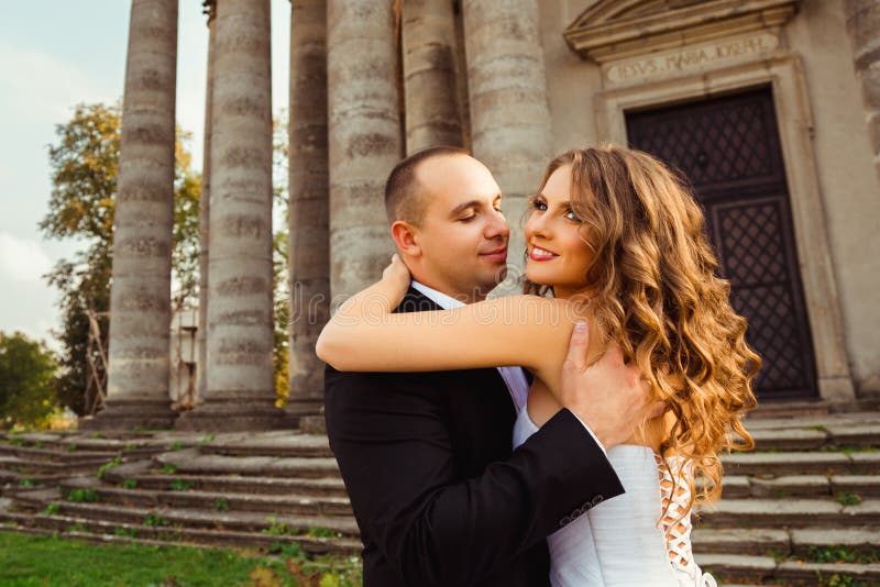 Novia hermosa que se coloca en el groom& x27; abrazos de s imágenes de archivo libres de regalías Novia hermosa que se coloca en el groom& x27; abrazos de s imágenes de archivo libres de regalías