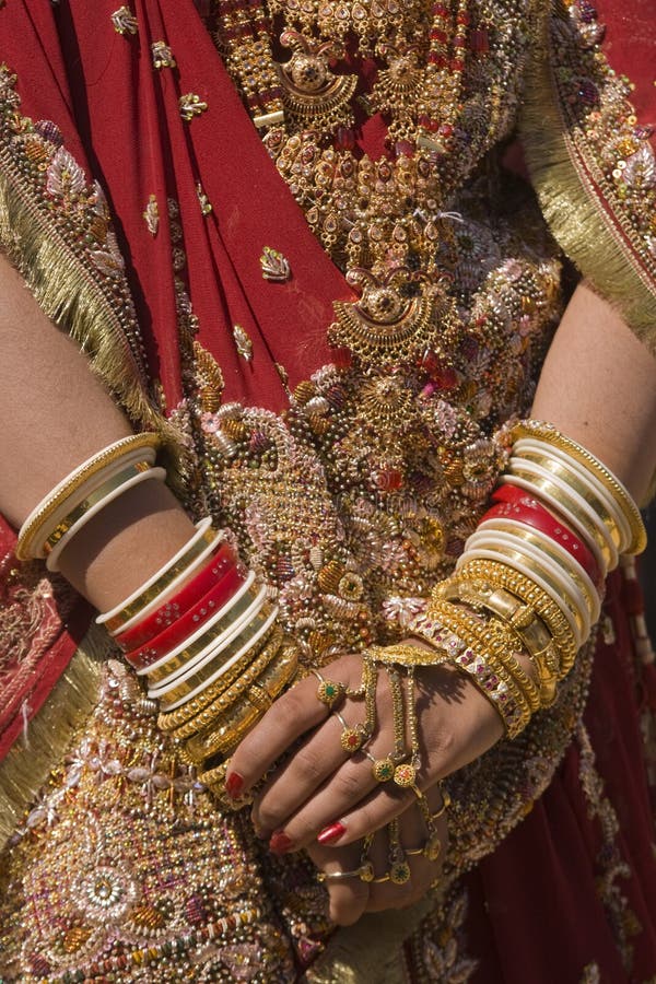 Hands of an Indian bride adorned with jewelery, bangles and painted with henna. Hands of an Indian bride adorned with jewelery, bangles and painted with henna.