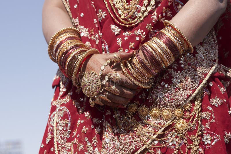 Hands of an Indian bride adorned with jewellery, bangles and painted with henna. Hands of an Indian bride adorned with jewellery, bangles and painted with henna.