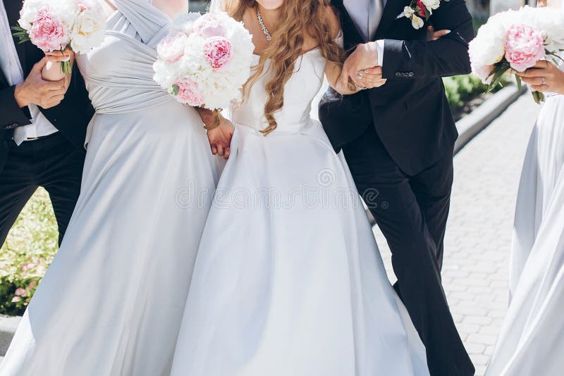 Novia magnífica con el ramo de la peonía y novio elegante que presenta en su foto de archivo Novia magnífica con el ramo de la peonía y novio elegante que presenta en su foto de archivo