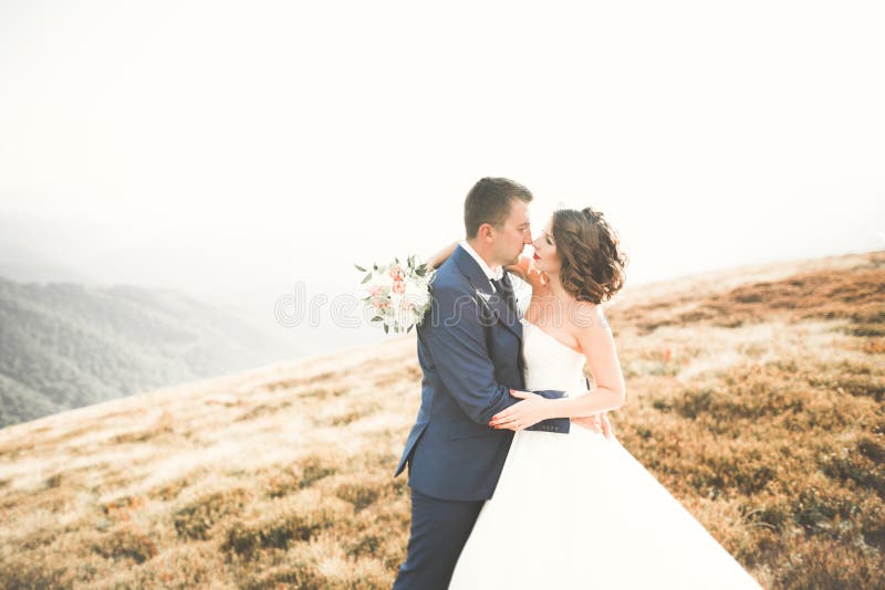 Novia magnífica hermosa que presenta para preparar y que se divierte, ceremonia de lujo en las montañas con la visión asombrosa, imágenes de archivo libres de regalías Novia magnífica hermosa que presenta para preparar y que se divierte, ceremonia de lujo en las montañas con la visión asombrosa, imágenes de archivo libres de regalías