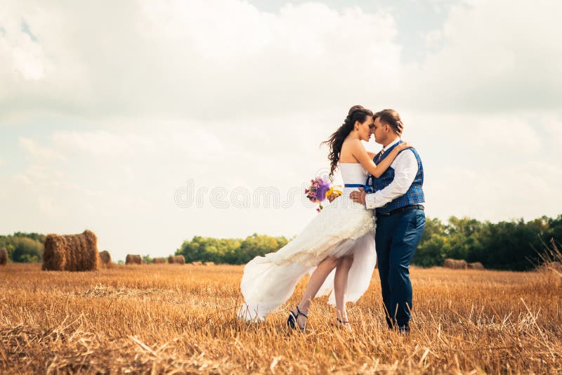 Novia y novio cerca del heno en un campo rural imagen de archivo Novia y novio cerca del heno en un campo rural imagen de archivo