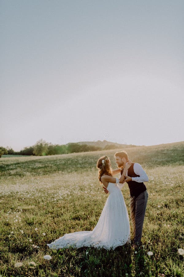 Novia y novio hermosos en la puesta del sol en naturaleza verde fotografía de archivo libre de regalías Novia y novio hermosos en la puesta del sol en naturaleza verde fotografía de archivo libre de regalías