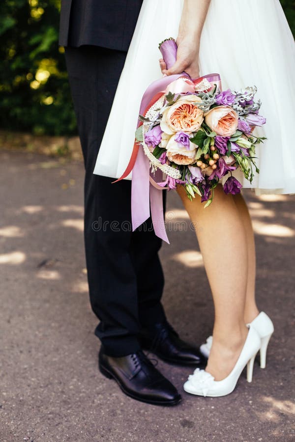 Novia y novio que se sientan al lado de un parque imagen de archivo libre de regalías Novia y novio que se sientan al lado de un parque imagen de archivo libre de regalías