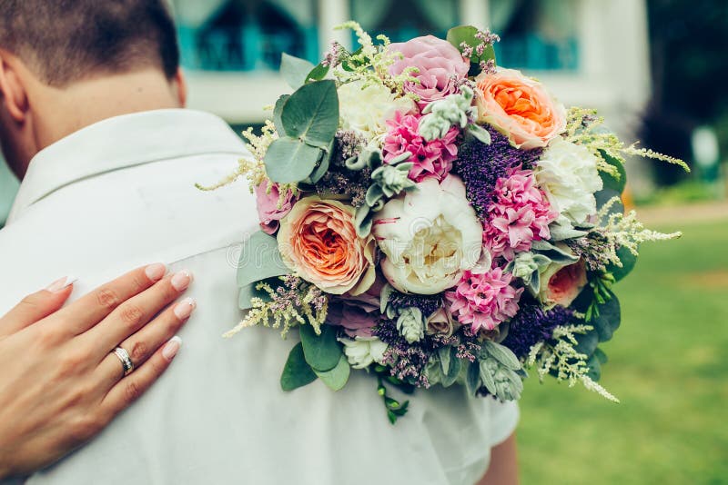 Novio del abrazo de la novia con el ramo de la boda fotos de archivo libres de regalías Novio del abrazo de la novia con el ramo de la boda fotos de archivo libres de regalías