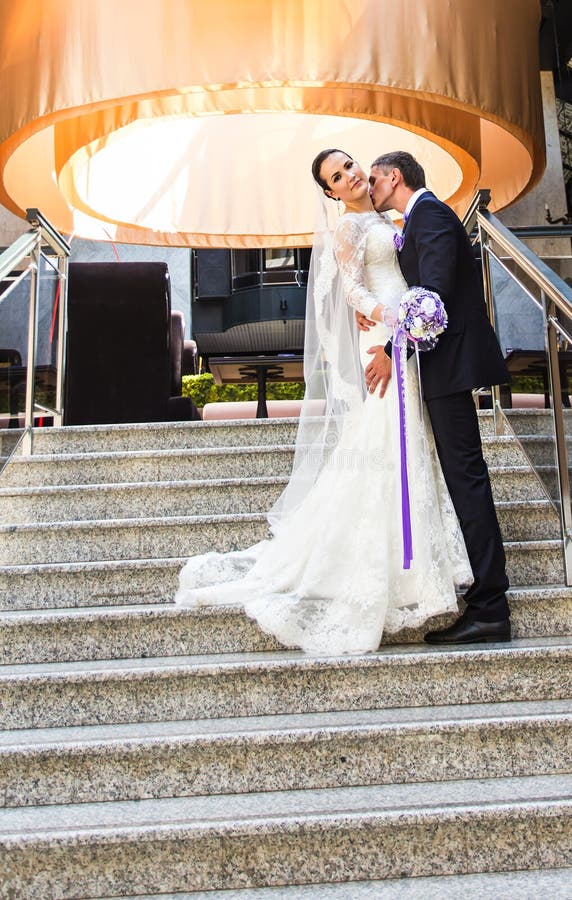 Novio hermoso que besa a la novia en cuello foto de archivo libre de regalías Novio hermoso que besa a la novia en cuello foto de archivo libre de regalías