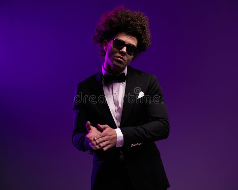 Novio joven sexy con pelo rizado y gafas de sol frotando las palmas imagen de archivo