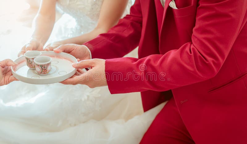 Burlas Nominal Acompañar Novio Y Novia En Ceremonia De Té El Día De La Ceremonia De Boda Novia Y  Novio Con Vestido De Novia Blanco Y Traje Rojo Sientan Y Foto de archivo -  Imagen