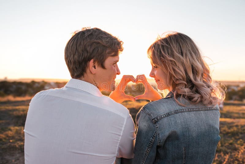 ` Novo feliz s dos pares que faz o coração dos dedos foto de stock ` Novo feliz s dos pares que faz o coração dos dedos foto de stock
