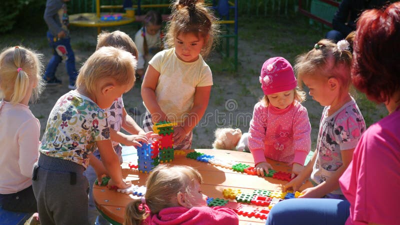 NOVOSIBIRSK, RUSSIA - August 16, 2017: In kindergarten, the woman playing with the children, active games outdoors royalty free stock image NOVOSIBIRSK, RUSSIA - August 16, 2017: In kindergarten, the woman playing with the children, active games outdoors royalty free stock image