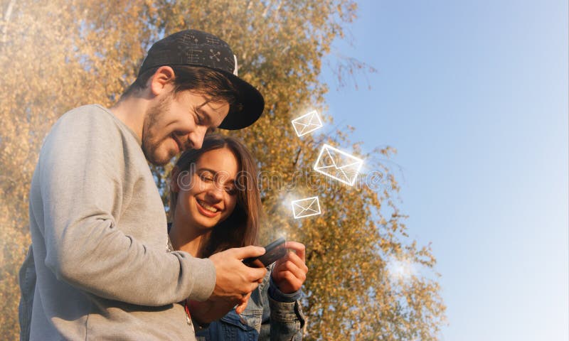 Nowe wiadomości na telefonie komórkowym szczęśliwe młode pary otwierające skrzynkę odbiorczą, aby wyświetlić oczekującą wiadomość