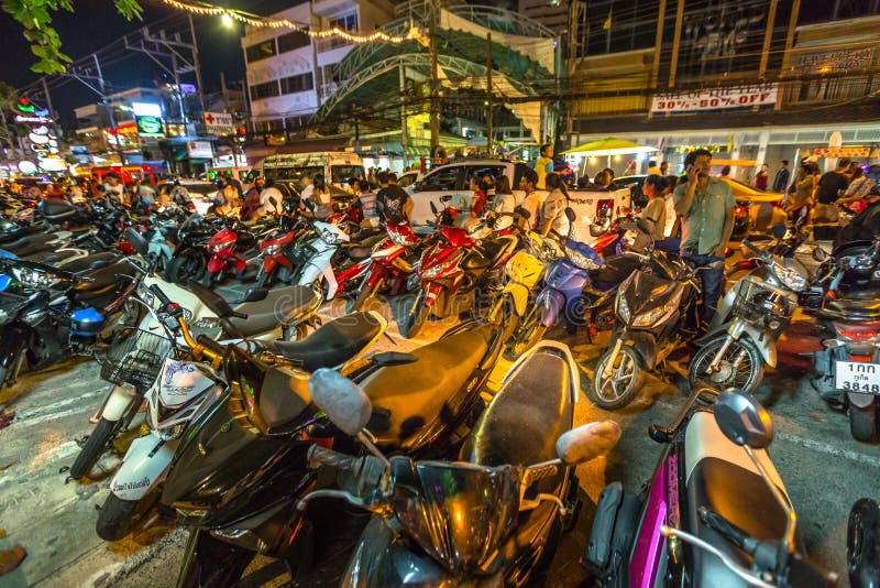 Patong, Phuket, Thailand - January 1, 2016:many scooters parked on sidewalk and street, crowd of tourists, local people with bikes and congested traffic during new year in Patong, famous for nightlife. Patong, Phuket, Thailand - January 1, 2016:many scooters parked on sidewalk and street, crowd of tourists, local people with bikes and congested traffic during new year in Patong, famous for nightlife