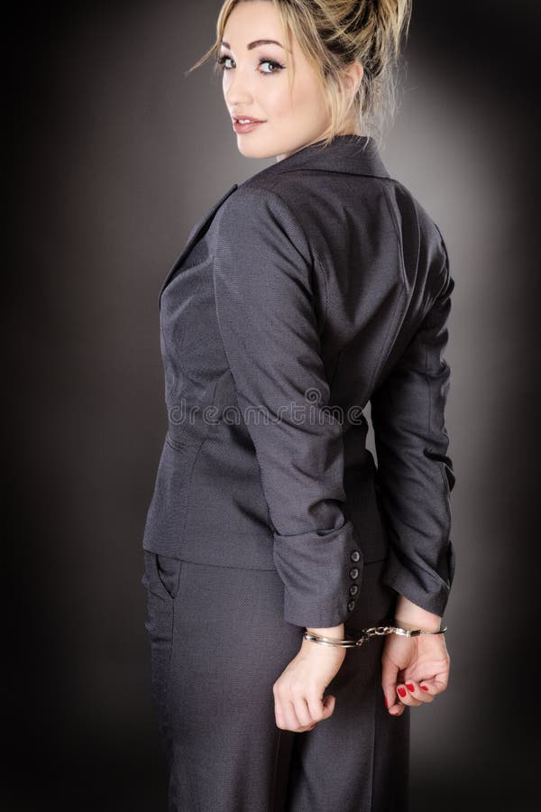 Business woman, handcuffed shot in the studio on a gray background.