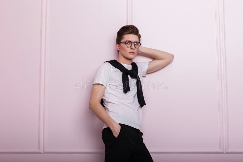 Nowoczesny, modny model młodzieńczy w stylowych okularach w modnej białej koszuli w vintage jeans z przekłuciem nosa fotografia royalty free