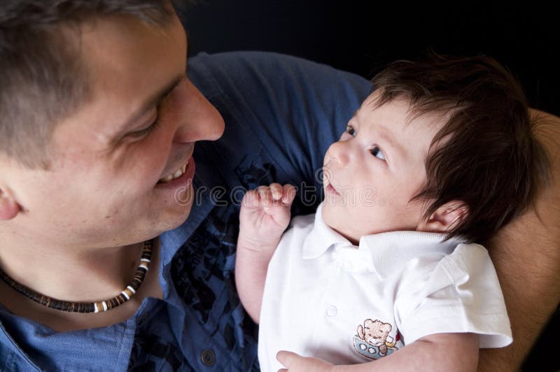 Portrait of a newborn son smiling at his father. Portrait of a newborn son smiling at his father.