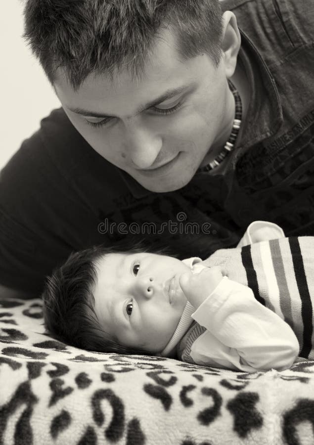 Portrait of a father looking at his newborn son. Portrait of a father looking at his newborn son.