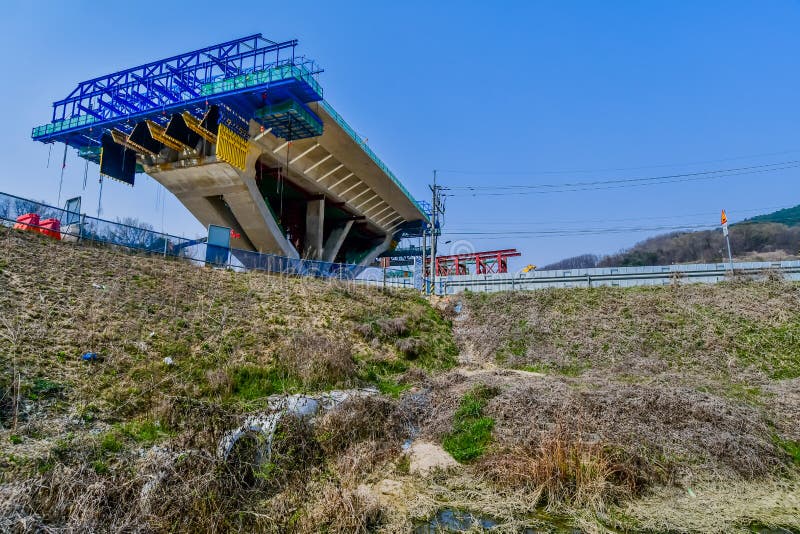 Sejong, South Korea; April 1, 2020: Section of new bridge under construction on spring day under clear blue sky. Sejong, South Korea; April 1, 2020: Section of new bridge under construction on spring day under clear blue sky